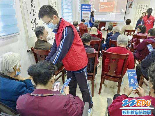 7学生志愿者给老人发放防诈骗宣传页_副本